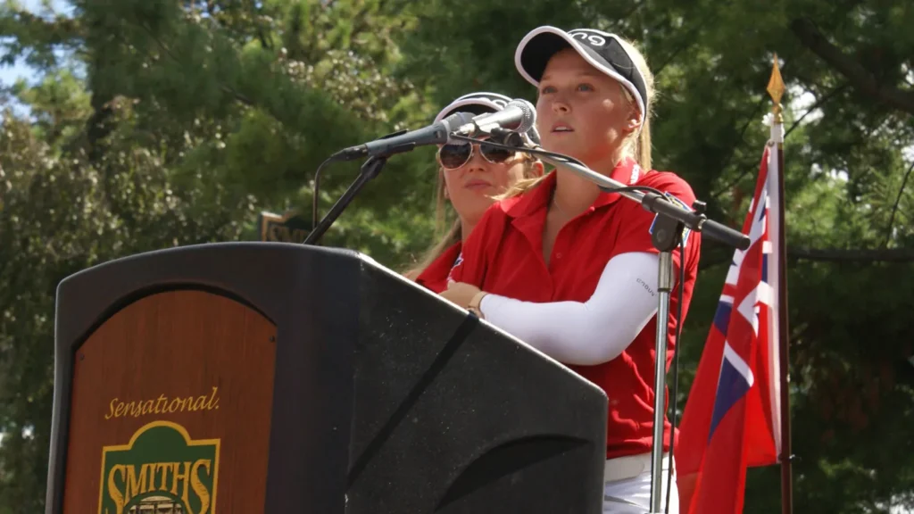 Brooke Henderson speaking into the microphone to a crowd.