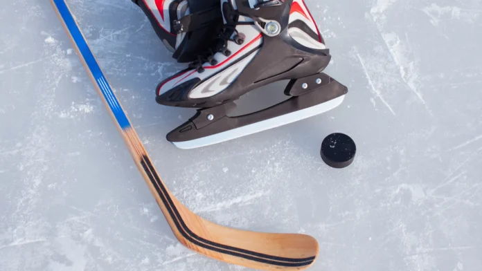 Hockey Stick and Puck on the Ice Rink