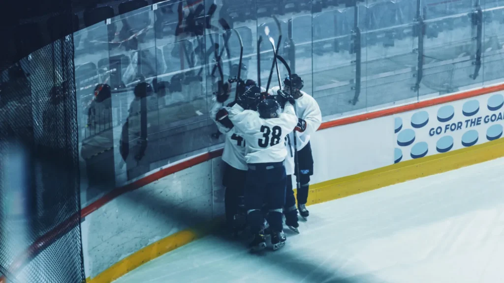 The ice hockey rink team celebrates victory near the board players.