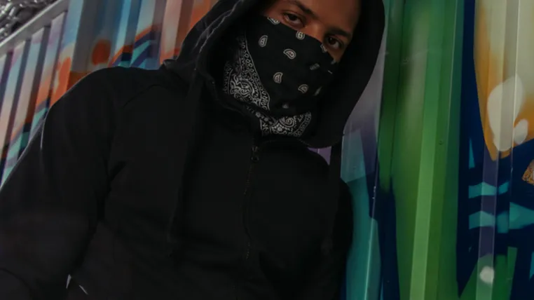 low angle view of african american vandal looking at camera