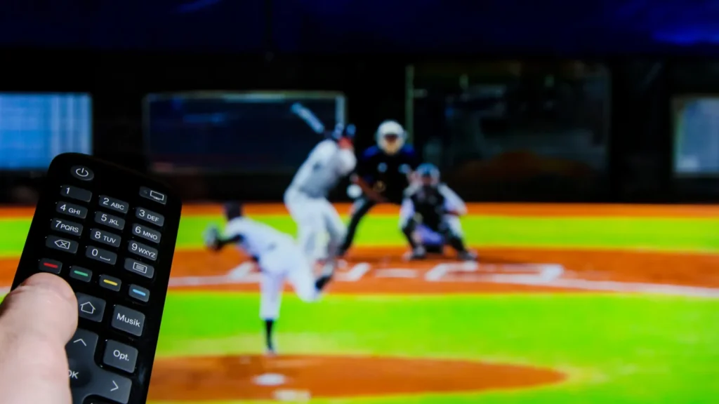 Man watching baseball on TV and using remote controller