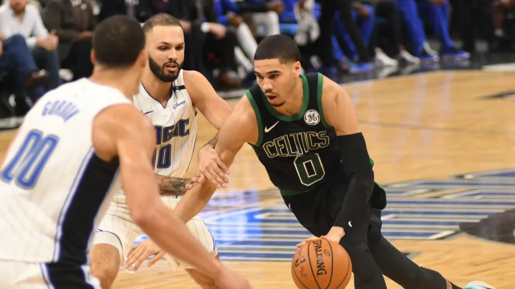 Jayson Tatum of Boston Celtics playing basketball in the court against oponents.