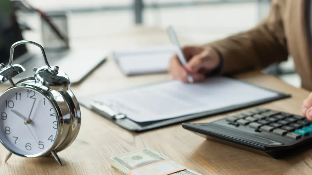 partial view of businessman signing contract near dollars calculator and alarm clock anticorruption concept
