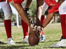 Photo of football players in huddle holding a football