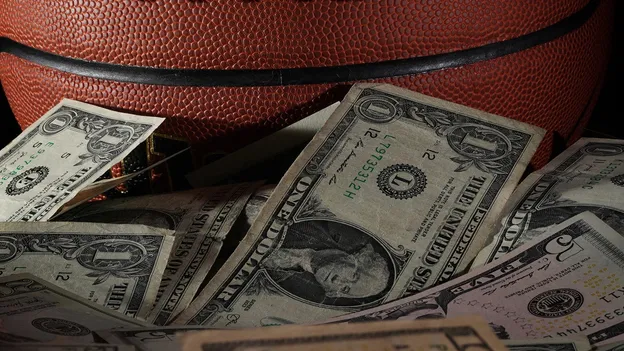 Basketball with dollars underneath it