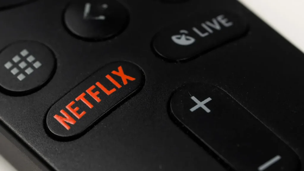 Russia Novosibirsk 10112021 Closeup of a black remote control with a netflix button on a white table