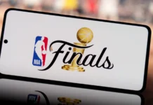 NBA acknowledges officiating error involving Stephon Castle in Finals Game 4 smartphone displaying nba finals logo with a blurred basketball court