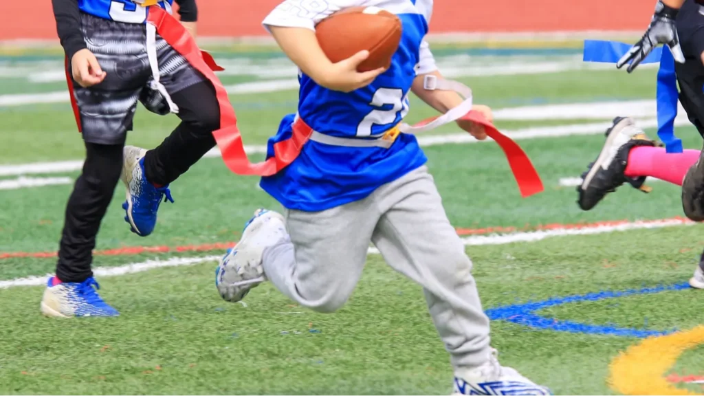 Young flag football player being chased down during a youth flag football game