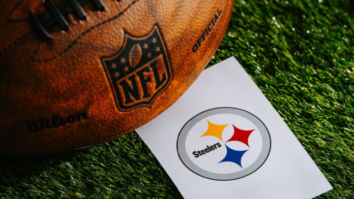 Pittsburgh Steelers NFL team Logo and American football ball on green grass