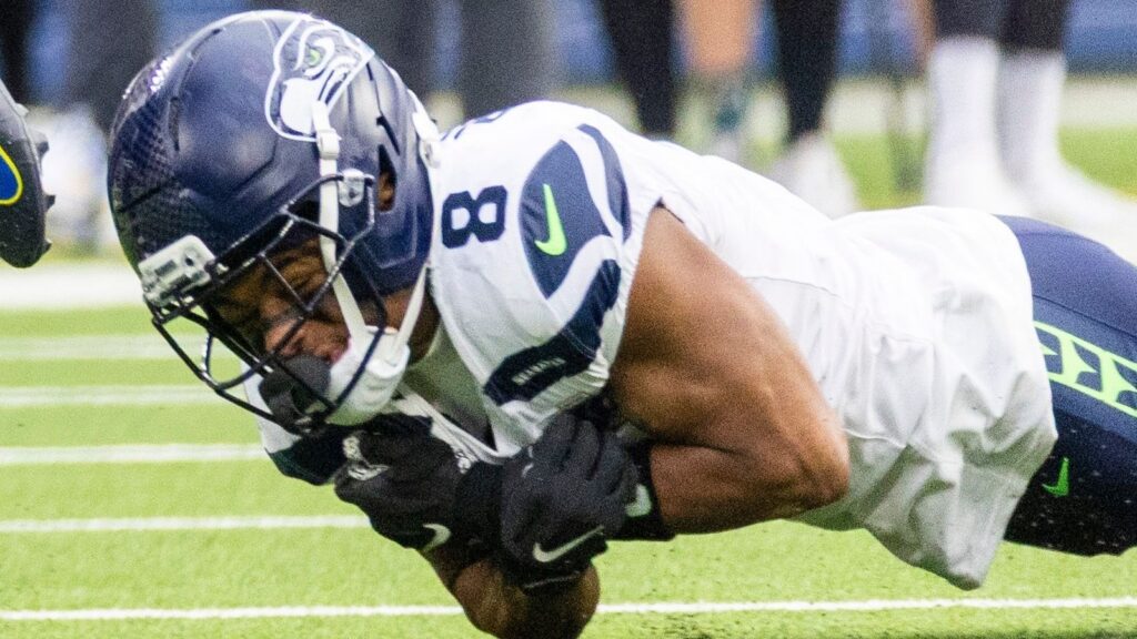 Coby Bryant (8) of Seattle Seahawks attempting to tackle the opponent player during a game.