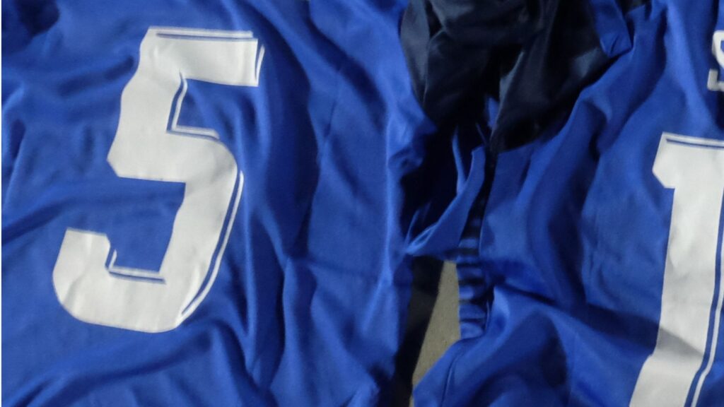 Close-up of blue-colored jersey with number 5 written on it.