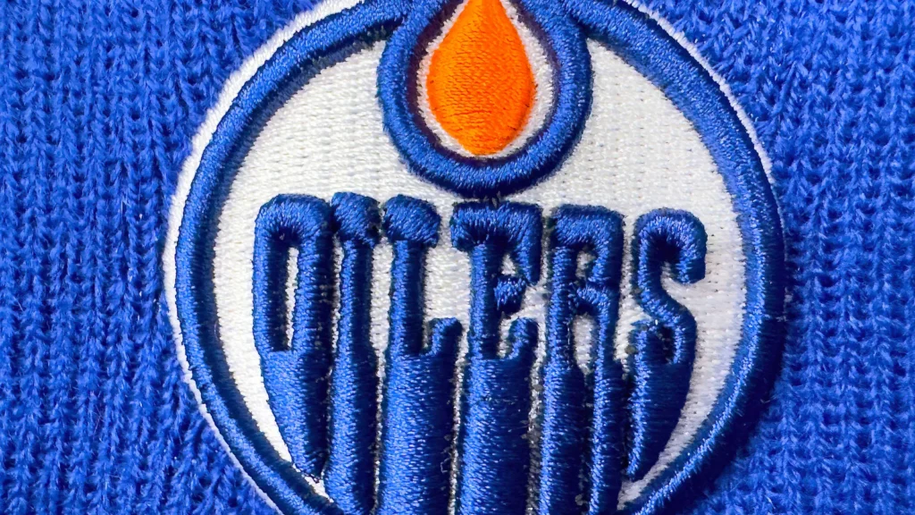 Calgary Alberta Canada Apr 10 2025 A closeup shows the embroidered Edmonton Oilers logo on a blue knit fabric The logo features