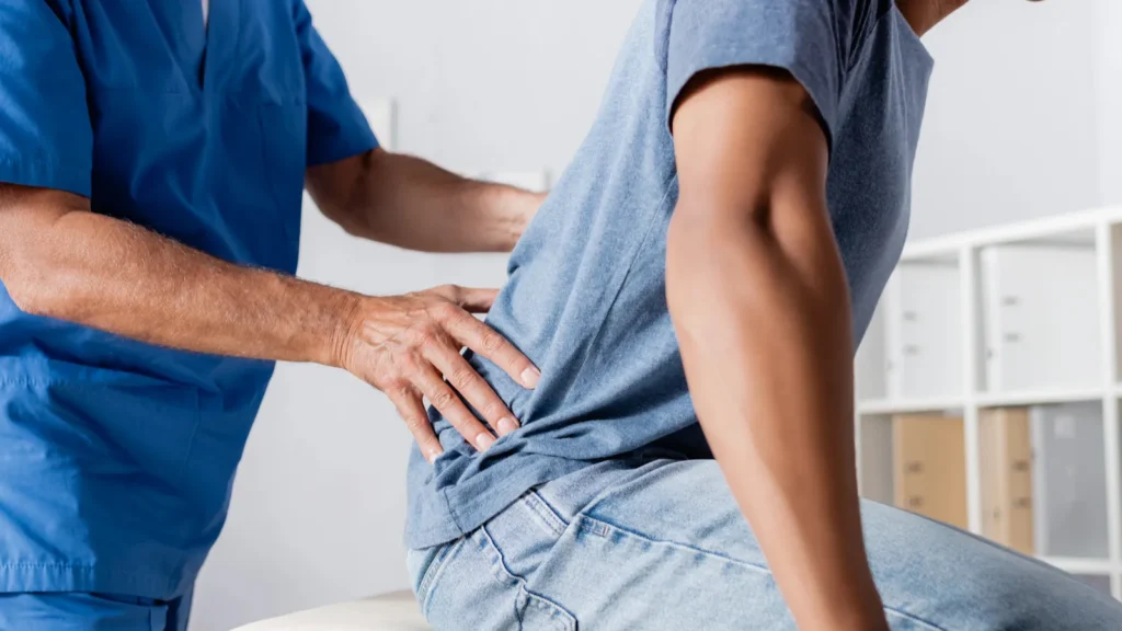 cropped view of mature chiropractor working with african american man
