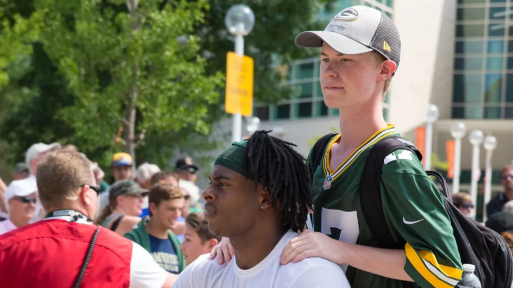 Green Bay Packer player riding bike with a young fan