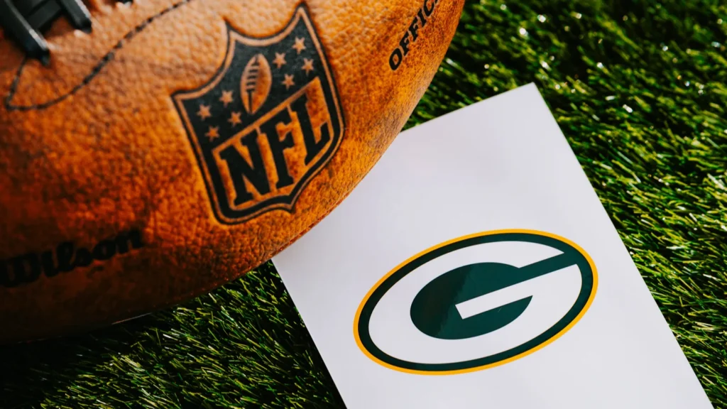 GREEN BAY USA FEBRUARY 10 2025 Green Bay Packers NFL team Logo and American football ball on Green Grass