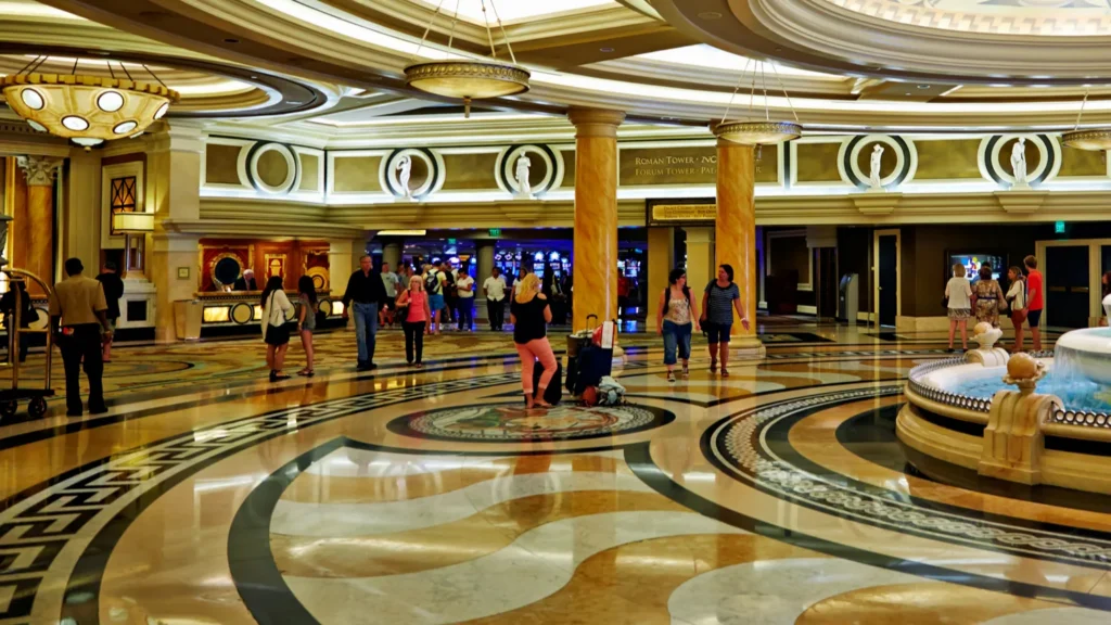 Guests walk through the lobby of Caesars Palace Hotel in Las Vegas Nevada The area features a large fountain and ornate design elements