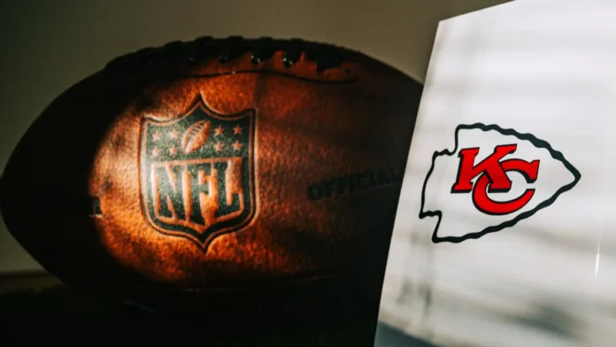 An official NFL football alongside the logo of the Kansas City Chiefs team