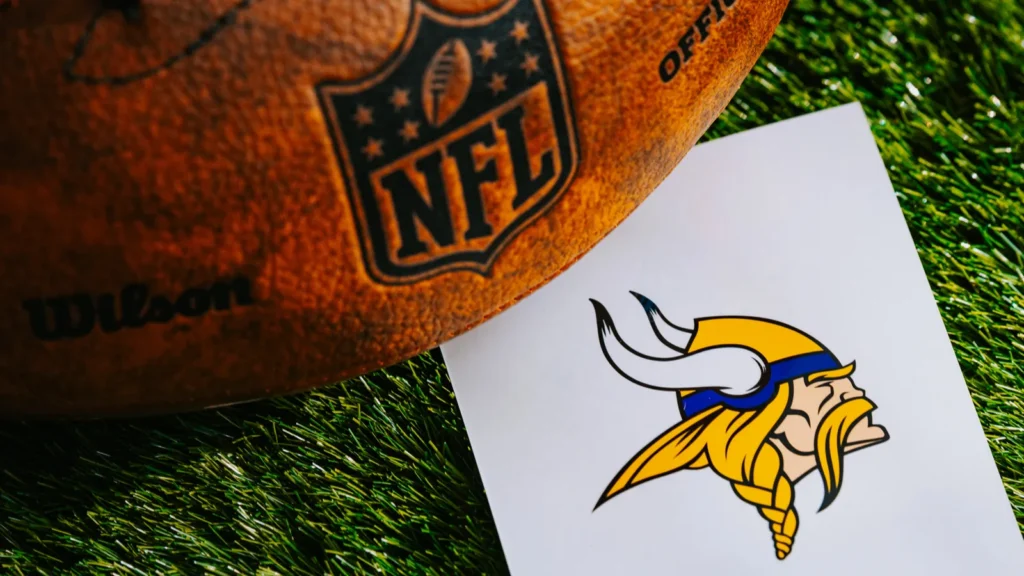 MINNEAPOLIS USA FEBRUARY 10 2025 Minnesota Vikings NFL team Logo and American football ball on Green Grass