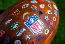 Why some NFL teams are worth billions more than their biggest rivals NEW YORK USA SEPTEMBER 11 2023 NFL football ball logo of national football league and logos of all teams Green background edit space