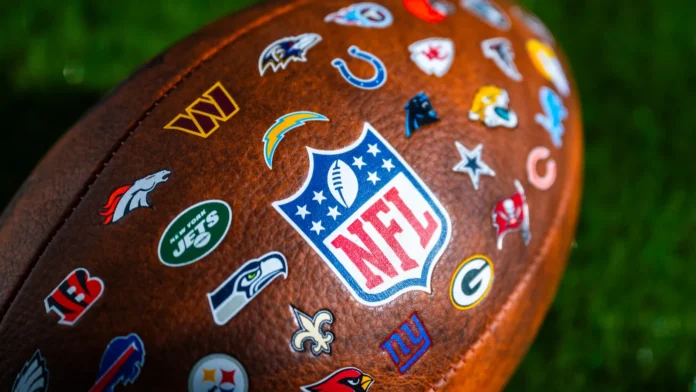 NEW YORK USA SEPTEMBER 11 2023 NFL football ball logo of national football league and logos of all teams Green background edit space