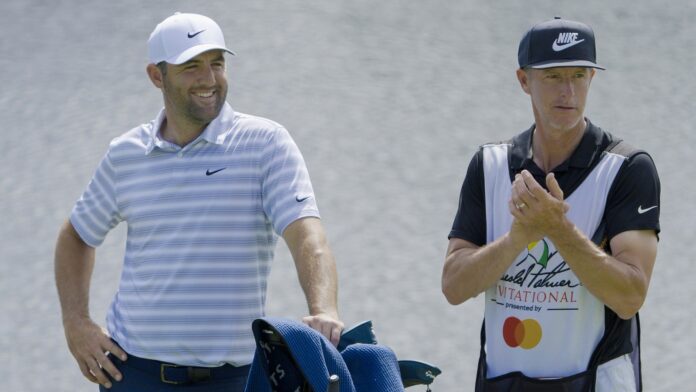 Scottie Scheffler (L) and his caddie Ted Scott wait on the 18th green during the Arnold Palmer Invitational