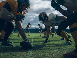 Two professional American football teams stand opposite each other ready to start the game.