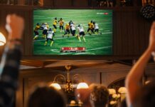 Netflix makes its biggest NFL move yet with expanded streaming deal American football fans cheer while watching a live match broadcast in a sports pub.