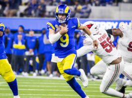 Los Angeles Rams' player holding a ball and running during the game.