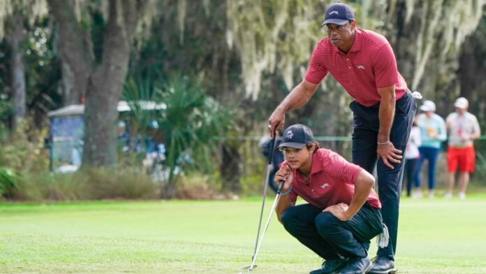 Shutterstock_Charlie woods and tiger woods_2563054637 Charlie Woods and Tiger Woods line up a putt together on a green during the PNC Championship