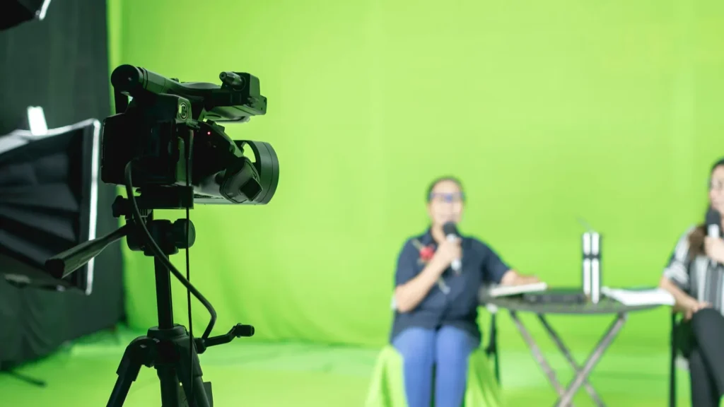 Behind the scenes of a livestream at a studio with greenscreen and a digital camcorder