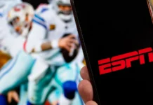 Ryan Clark learns of ESPN layoff during live broadcast of NFL Live ESPN logo on a mobile phone screen with NFL players in action in the background