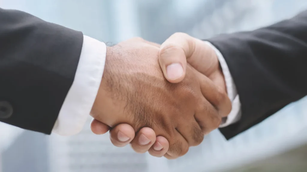 Closeup of a businessman hand shake investor between two colleagues OK succeed in business Holding hands