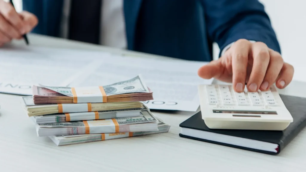 A businessman using calculator near money and contract