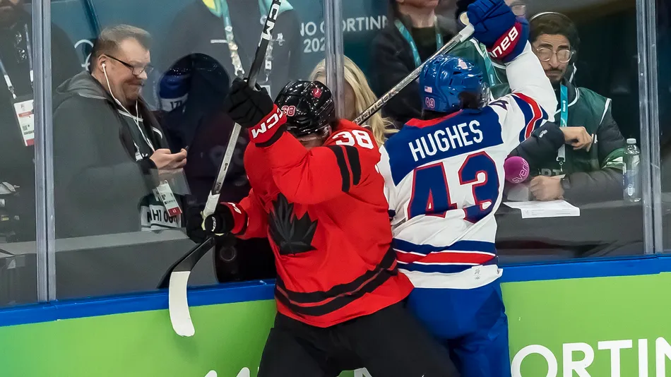 Defender Quinn Hughes 43 of Team United States fights for the puck against Team Canada