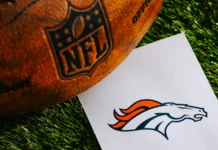Denver Broncos NFL team Logo and NFL American football ball on green grass