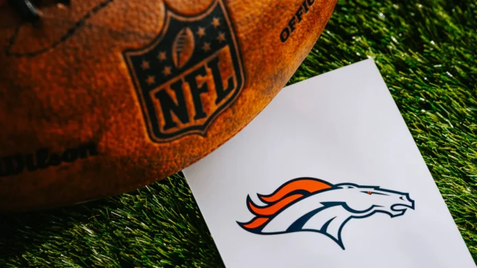 DENVER USA FEBRUARY 10 2025 Denver Broncos NFL team Logo and American football ball on Green Grass Denver Broncos NFL team Logo and NFL American football ball on green grass