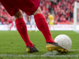 Footballer takes the corner Detail of players legs and the ball during soccer match
