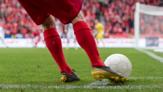 Footballer takes the corner Detail of players legs and the ball during soccer match