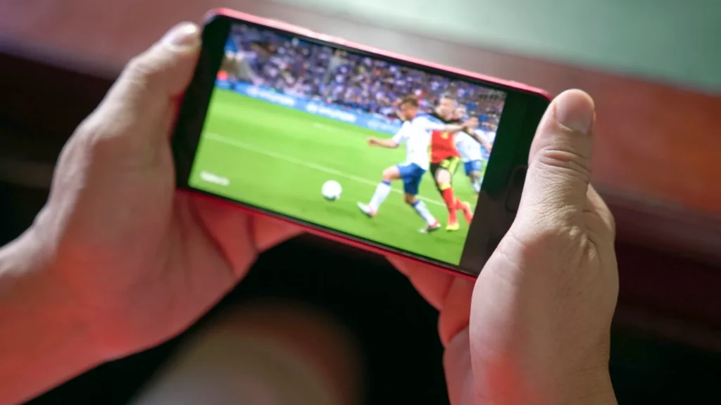 Man watching football and sport stream on mobile phone.