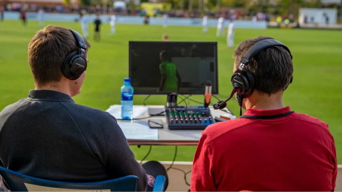 Back view of commentators commentating on a game