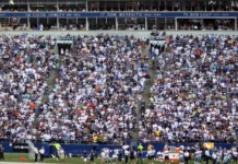 A crowd of spectators in a football stadium, featuring a Dallas Cowboys Ring of Honor section