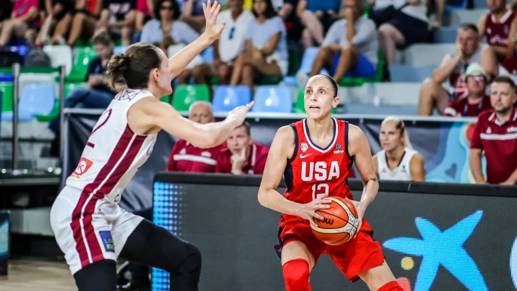 Diana Taurasi playing basketball while the opponent player tries to block her.