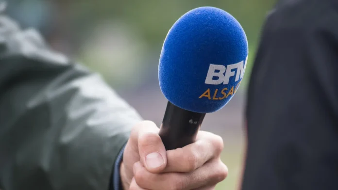 Strasbourg France 17 September 2022 Closeup of blue bfmtv microphone in hand of journalist in the street Strasbourg France 17 September 2022 Closeup of blue bfmtv microphone in hand of journalist in the street