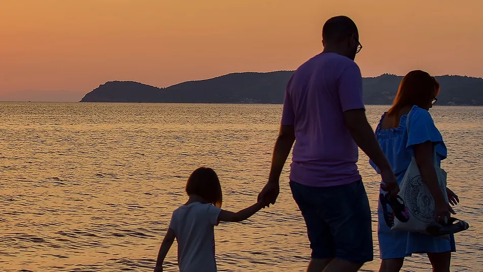 The silhouette of family watching the sunrise on the beach
