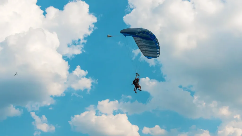 Two men flying in the blue sky using parachute