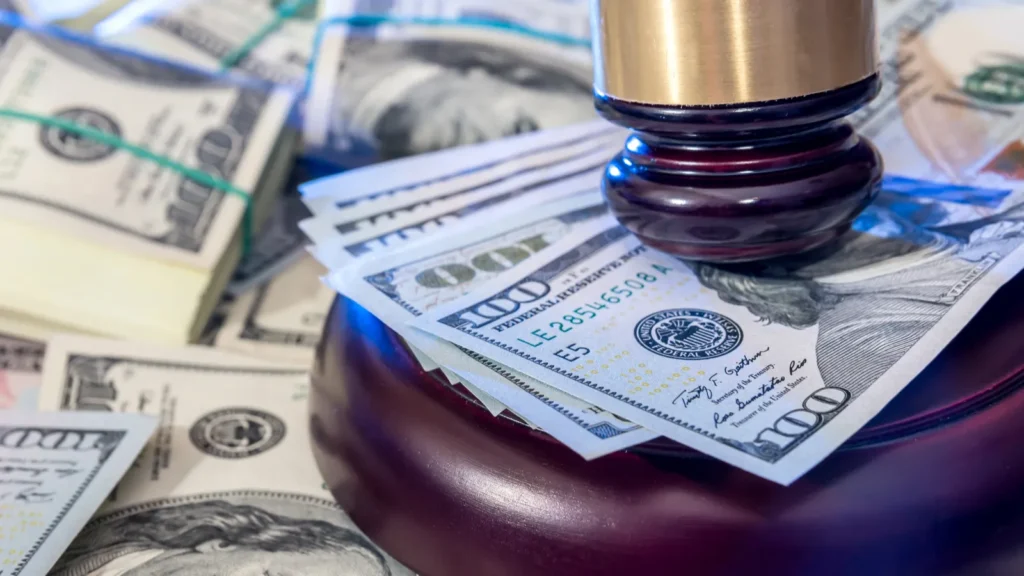 Wooden law gavel on Dollar notes in the background