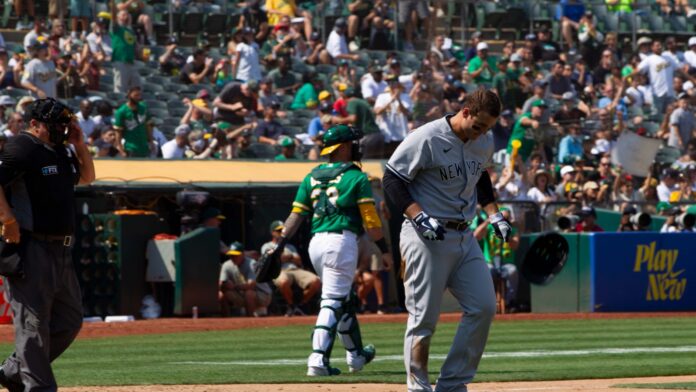 New York Yankees' Anthony Rizzo #48 slams his helmet after striking out during a game against the Oakland Athletics at RingCentral Coliseum.