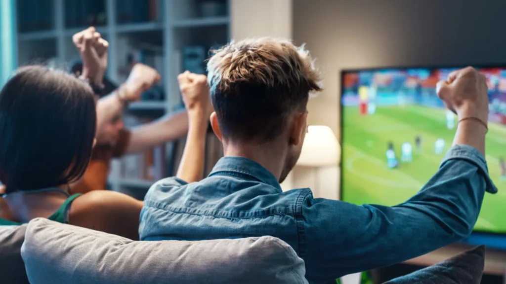 Group of friends watching a football match on TV