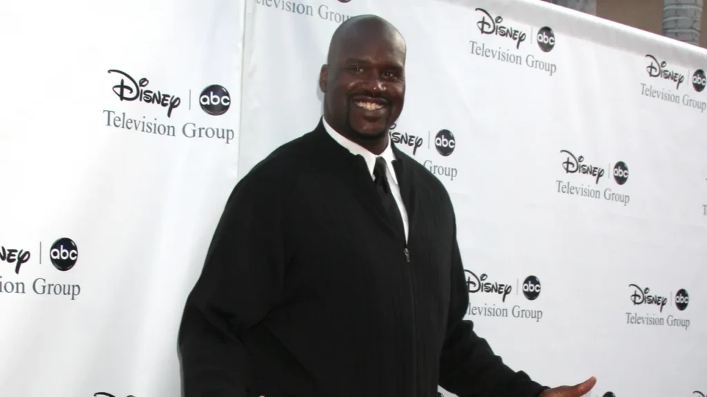Former professional basketball player shaquille-o-neal posing on a red carpet at a Disney ABC Television Group event.