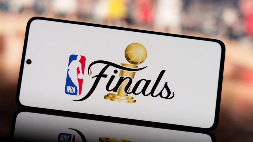 Smartphone displaying NBA finals logo with a blurred basketball court in the background
